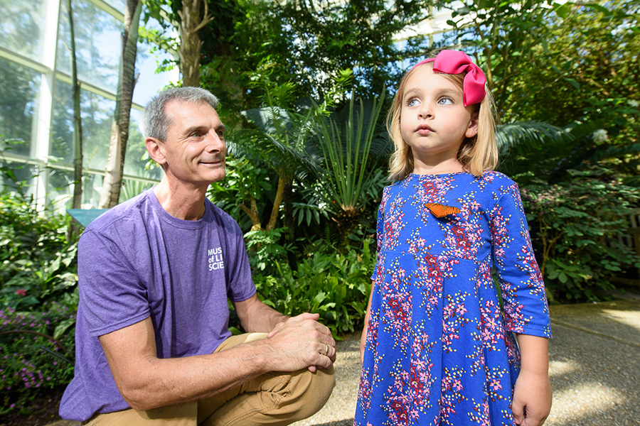 Staff member with young guest admire butterfly