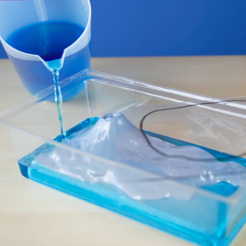 glass container with blue liquid being poured into it